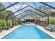 Relaxing screened-in pool area with ample seating and lush landscaping at 1930 Country Club Rd, Eustis, FL 32726