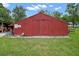 Exterior view of a red barn featuring sturdy wooden doors and secure perimeter at 19703 Lake Lincoln Ln, Eustis, FL 32736