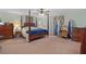 Spacious bedroom with a four-post bed, ceiling fan, and sitting area at 19703 Lake Lincoln Ln, Eustis, FL 32736