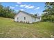 Side view of a one-story home with a gray roof and green yard, set against a blue sky at 19703 Lake Lincoln Ln, Eustis, FL 32736