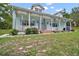 Charming single story home boasts a light blue exterior, dormer windows, and a spacious front porch at 19703 Lake Lincoln Ln, Eustis, FL 32736