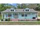 Charming home with dormer windows, front porch with decorated pillars and a light blue exterior at 19703 Lake Lincoln Ln, Eustis, FL 32736