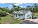 Charming home has a light blue exterior, dormer windows, front porch, and surrounding green landscape at 19703 Lake Lincoln Ln, Eustis, FL 32736