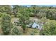 Exterior of cozy blue house with a well maintained lawn and mature trees at 19703 Lake Lincoln Ln, Eustis, FL 32736