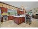 Spacious kitchen with breakfast bar, tiled floors, and wood cabinets at 19703 Lake Lincoln Ln, Eustis, FL 32736