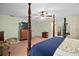 Spacious main bedroom with four-poster bed, ceiling fan, and ensuite bathroom at 19703 Lake Lincoln Ln, Eustis, FL 32736
