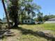 Wide view of a dilapidated home surrounded by trees and an overgrown yard at 2001 Bates Ave, Eustis, FL 32726