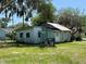 Dilapidated home with weathered siding, damaged roof, and overgrown front yard at 2001 Bates Ave, Eustis, FL 32726