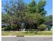 Front exterior of a home partially obscured by trees, featuring a small porch and steps, indicating a property in need of landscaping at 2001 Bates Ave, Eustis, FL 32726