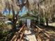 Quaint home with a wooden walkway, surrounded by trees draped with Spanish moss at 2001 Bates Ave, Eustis, FL 32726