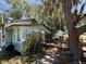 Cozy home exterior, featuring a small wooden deck and a charcoal grill, shaded by mature trees at 2001 Bates Ave, Eustis, FL 32726