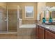 Bright bathroom with tile flooring features a separate tub, glass shower enclosure, and vanity with granite counters at 2064 Rafton Rd, Apopka, FL 32703