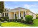 Inviting exterior view of the house showcasing its lush landscaping, columns and well-manicured lawn at 2064 Rafton Rd, Apopka, FL 32703