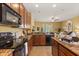 Well-lit kitchen featuring granite countertops, wooden cabinets, and modern appliances with seamless access to the living area at 2064 Rafton Rd, Apopka, FL 32703