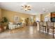 Inviting living room showcases neutral-toned decor, a ceiling fan, tile flooring, and seamless access to the dining area at 2064 Rafton Rd, Apopka, FL 32703