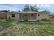 Backyard exterior of the home featuring a screened patio and stone retaining wall at 209 Edgewood Dr, Clermont, FL 34711