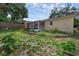Landscaped backyard exterior of the home featuring a screened patio and brick wall at 209 Edgewood Dr, Clermont, FL 34711