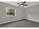 Neutral bedroom featuring wood-look tile floors and a window overlooking the backyard at 209 Edgewood Dr, Clermont, FL 34711