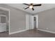 This spacious bedroom features wood-look tile floors, neutral paint, a ceiling fan, and an ensuite bathroom and closet at 209 Edgewood Dr, Clermont, FL 34711