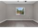 Neutral bedroom featuring wood-look tile floors and a window overlooking the backyard at 209 Edgewood Dr, Clermont, FL 34711
