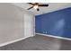 This bedroom features wood-look tile floors, neutral paint, a ceiling fan, and a blue accent wall at 209 Edgewood Dr, Clermont, FL 34711