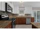 Modern kitchen featuring stainless steel appliances, granite countertops, and custom cabinets at 209 Edgewood Dr, Clermont, FL 34711