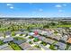 A sunny aerial view of a charming single-Gathering home in a well-maintained community with lush landscaping and waterways at 2160 Biller Cir, The Villages, FL 32163