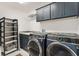 Well-equipped laundry room featuring modern washer and dryer, ample storage, and a utility sink at 2160 Biller Cir, The Villages, FL 32163