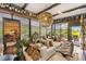 Sunroom living room with a cozy couch, decorative plants, and decorative wine collection on display at 2160 Biller Cir, The Villages, FL 32163
