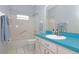 Bathroom features a white vanity, blue countertop, with a tiled tub and shower combination at 21926 King Alfred St, Leesburg, FL 34748