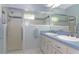 Bathroom featuring a double sink vanity with white cabinets and a glass-enclosed shower at 21926 King Alfred St, Leesburg, FL 34748