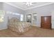 Bright bedroom features neutral carpet, a queen bed with floral bedding, and views to the Primary bath at 21926 King Alfred St, Leesburg, FL 34748