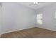 The bedroom has neutral carpet and light gray walls with a window and a ceiling fan with lights at 21926 King Alfred St, Leesburg, FL 34748