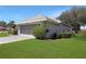 The exterior angle shows the spacious side entry garage and manicured lawn at 21926 King Alfred St, Leesburg, FL 34748