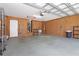 Spacious garage with painted walls, storage shelves, and a clean epoxy floor at 21926 King Alfred St, Leesburg, FL 34748