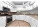 Modern kitchen featuring stainless steel appliances, white cabinets, and updated countertops at 21926 King Alfred St, Leesburg, FL 34748