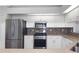 Well-equipped kitchen showcasing stainless steel appliances, white cabinetry, and modern backsplash at 21926 King Alfred St, Leesburg, FL 34748