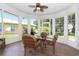 Sunroom with tiled floors and many windows showcasing the view of the landscaped yard at 21926 King Alfred St, Leesburg, FL 34748