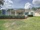 This beautiful backyard features a screened lanai, manicured lawn, and lush landscaping, creating a private outdoor retreat at 2415 Twickingham Ct, Clermont, FL 34711