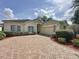Charming home featuring a brick driveway, manicured landscaping, and a welcoming entrance at 2415 Twickingham Ct, Clermont, FL 34711