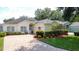 Charming one-story home with manicured lawn, brick driveway, and a welcoming facade at 2415 Twickingham Ct, Clermont, FL 34711
