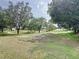 Lush green golf course with mature trees and rolling hills creates a scenic backdrop at 2415 Twickingham Ct, Clermont, FL 34711