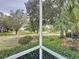 Serene view of the golf course from the screened-in patio, framed by lush greenery and mature trees at 2415 Twickingham Ct, Clermont, FL 34711