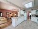 An open kitchen showcasing white cabinets, tile backsplash, and a sun roof, offering a sunlit cooking space at 2415 Twickingham Ct, Clermont, FL 34711