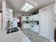 Bright kitchen with white cabinets, stainless sink, a microwave, oven, and a skylight overhead at 2415 Twickingham Ct, Clermont, FL 34711