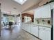 Kitchen featuring white cabinets, white appliances, tile floors, and open floorplan at 2415 Twickingham Ct, Clermont, FL 34711
