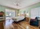 Bright and airy main bedroom featuring a ceiling fan, hard wood floors, and a sliding glass door to a lanai at 2415 Twickingham Ct, Clermont, FL 34711