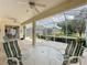 Screened lanai with ceiling fans and outdoor seating offers a relaxing space to enjoy views of manicured landscaping at 2415 Twickingham Ct, Clermont, FL 34711