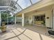 Large screened-in patio with ample seating and a view of the lush landscaping at 2415 Twickingham Ct, Clermont, FL 34711