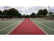 View of tennis courts featuring a green and red hard surface, enclosed by a dark fence at 2415 Twickingham Ct, Clermont, FL 34711